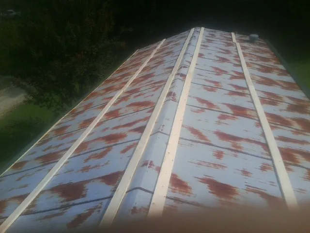Rusted metal roof panels with new wood purlins before replacement — Storm Damage Roof Repair in Tamassee by Roofing Brothers