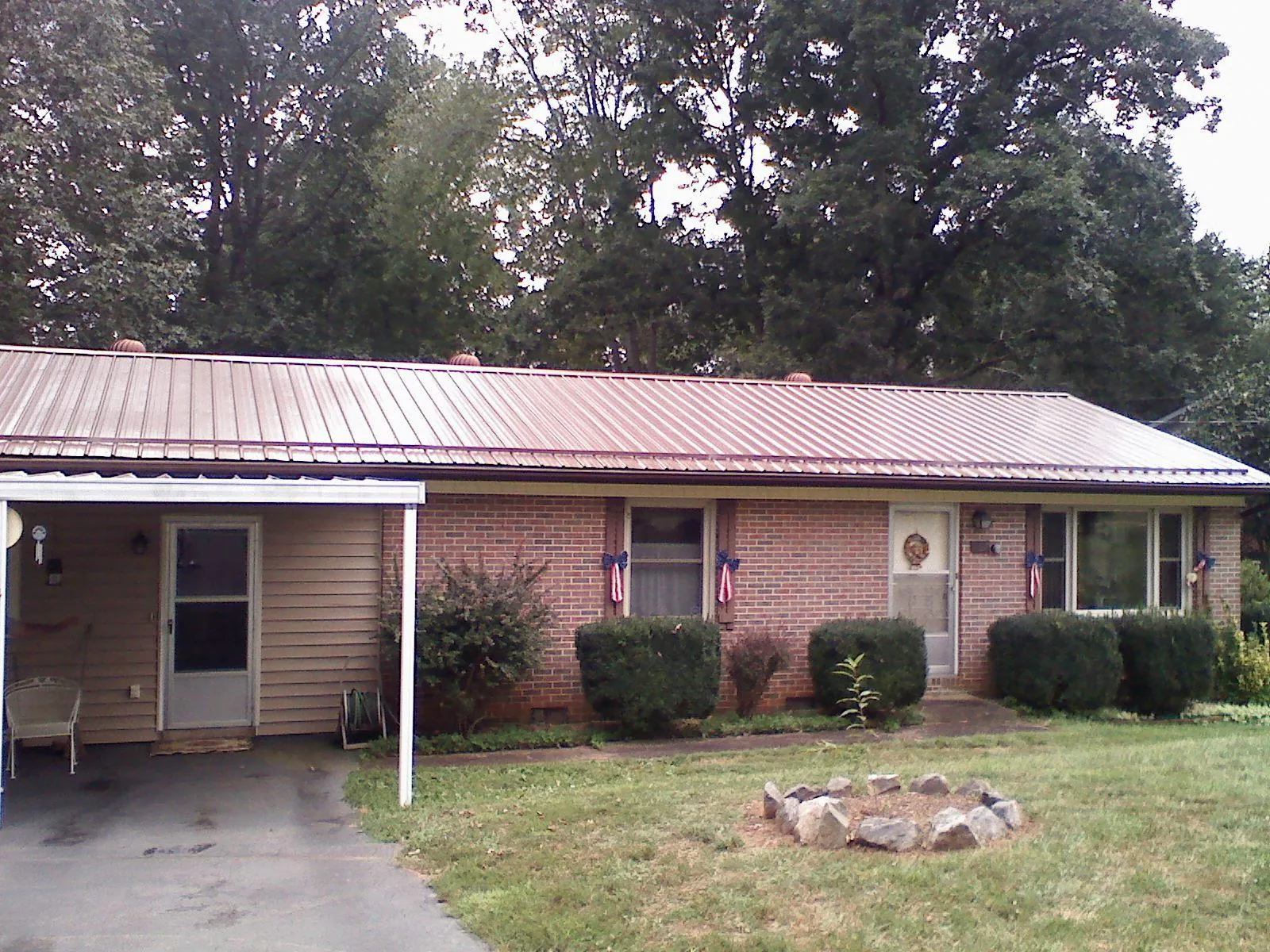 Bronze metal roof and carport on a brick ranch home — Roof Repair work by our crew in Tamassee